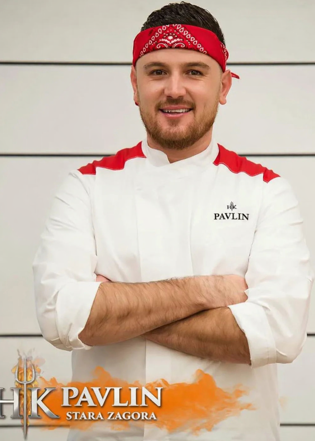 Chef wearing a hells kitchen uniform with 'Pavlin' branding, standing against a light background.