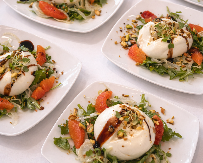 Plated salads with burrata and arugula with citrus segments